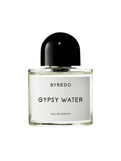 A bottle of Baccarats Gypsy Water EDP For Men and Women. The transparent cylindrical glass bottle features a white label with black text and a black rounded cap. Embracing the essence of nomadism, the fragrance name "Gypsy Water" and "Eau de Parfum" are elegantly displayed on the label.