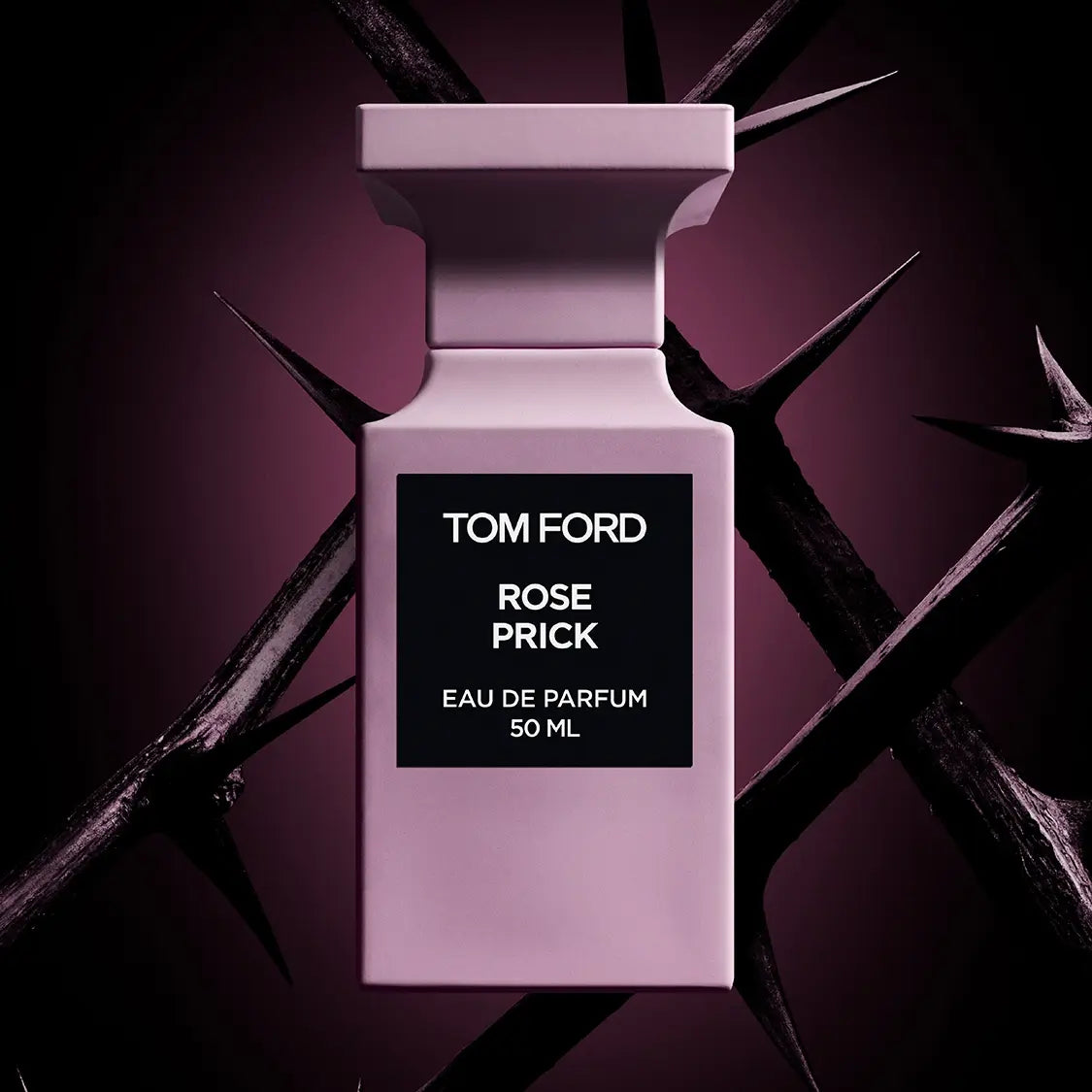 A pink bottle of Baccarats' Tom Ford Rose Prick Eau de Parfum for Men and Women, 100 ml, emits a warm floral fragrance that evokes the essence of a secluded rose garden. It features a black rectangular label displaying the brand and fragrance name, set against its sleek, minimalist design.