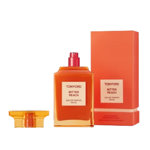 A 100 ml bottle of Baccarats Tom Ford Bitter Peach Eau De Parfum for Men and Women features a warm orange hue that reflects the luxuriant notes of Sicilian blood orange oil and sandalwood absolute, with a square label displaying both the brand and fragrance name.