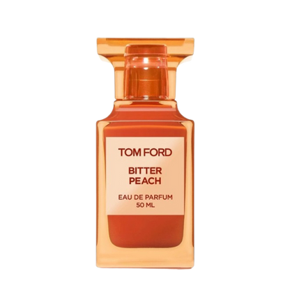 A 100 ml bottle of Baccarats Tom Ford Bitter Peach Eau De Parfum for Men and Women features a warm orange hue that reflects the luxuriant notes of Sicilian blood orange oil and sandalwood absolute, with a square label displaying both the brand and fragrance name.