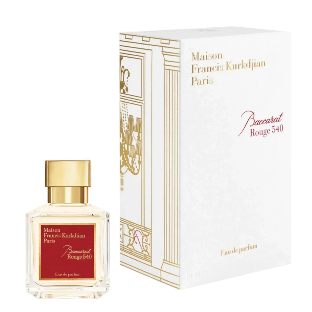 A transparent glass bottle of perfume with a gold cap, featuring "Baccarats Baccarat Rouge 540 Eau de Parfum for Men and Women" in gold and white text on a red background, embodies the essence of an amber floral fragrance.